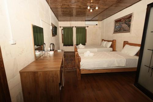a bedroom with two beds and a desk in it at Osmanlı Konağı - Şerif Paşa Butik Otel in Urfa