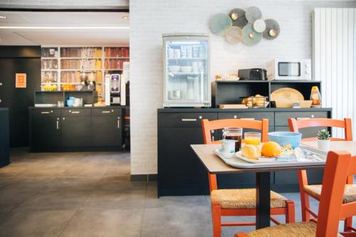 a kitchen with a table with a plate of oranges on it at Twenty Business Flats Nîmes Trigone in Nîmes