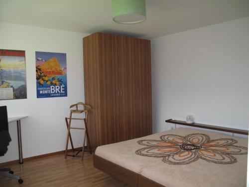 1 dormitorio con 1 cama y armario de madera en Casa Foletta, en Cugnasco