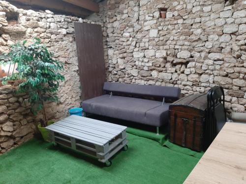 a bench in a room with a stone wall at Appartement Le Patio in Chauvigny