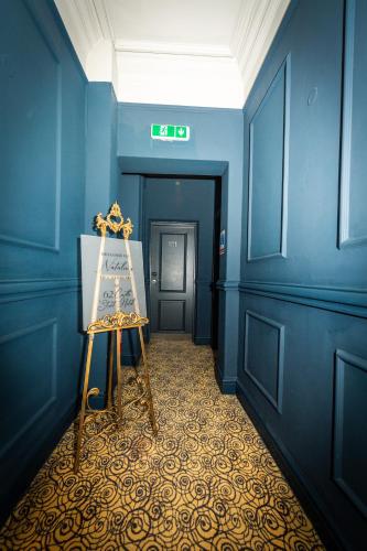 a blue hallway with a painting on a easel in it at 62 Castle Street Hotel in Liverpool