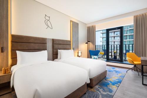 two beds in a hotel room with a view at voco Dubai The Palm by IHG in Dubai