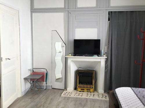 - une chambre avec un lit, une télévision et une cheminée dans l'établissement Avec un minimum de 3 nuits Studio 80 m de la mer et 300 m des commerces, au Tréport