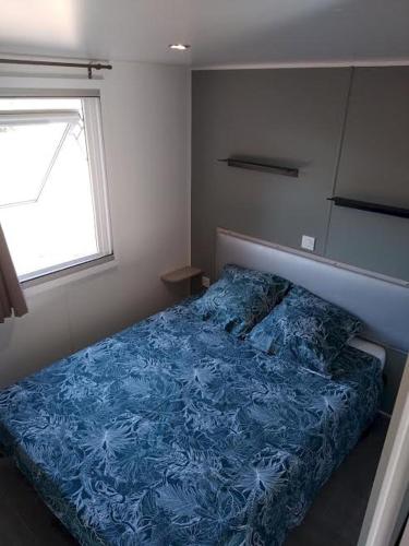 une chambre avec un lit avec une couverture bleue dans l'établissement Joli 2 chambres sur Lumio, vue à couper le souffle., à Lumio