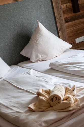 two white beds with towels on top of them at Ferienwohnung Grundlsee - Your Austrian Home in Grundlsee