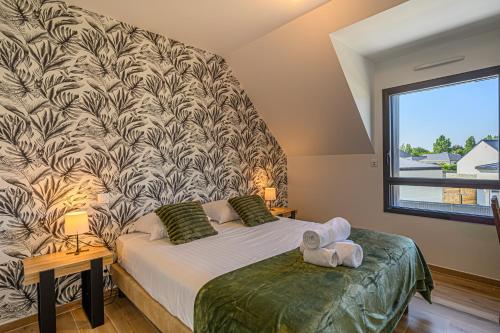 ein Schlafzimmer mit einem Bett und einem großen Fenster in der Unterkunft Villa Almaé - Maison neuve proche plages avec piscine chauffée in Ambon
