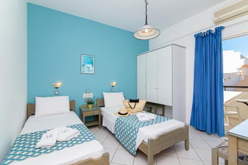 a room with two beds and a kitchen at Sunshine Garden Apts in Malia