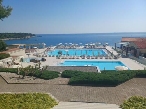 a view of a pool with umbrellas and the ocean at Apartments Eva in Pula