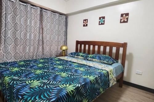 1 dormitorio con 1 cama con manta azul y verde en The Hideout en Suva