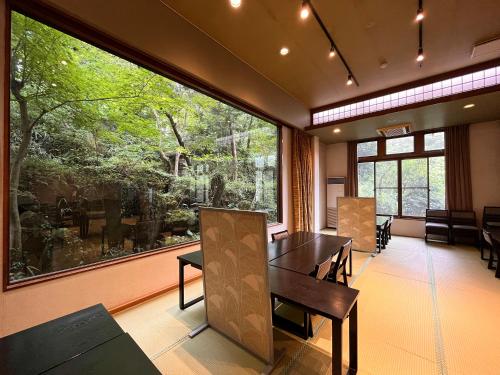 a dining room with a table and a large window at 丸山鉱泉旅館 in Nitanzawa