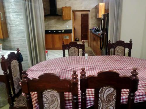 uma sala de jantar com uma mesa com uma toalha de mesa xadrez vermelha em Sinai Homestay em Alappuzha