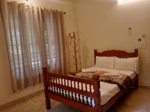 ein Schlafzimmer mit einem Holzbett und einem Fenster in der Unterkunft Sinai Homestay in Alappuzha