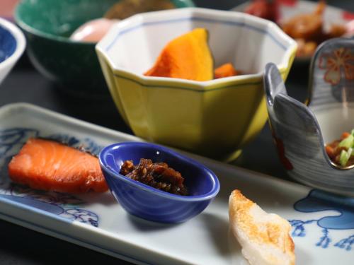 a tray with a blue bowl of food and carrots at 丸山鉱泉旅館 in Nitanzawa