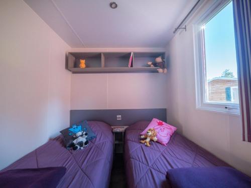 - une chambre dotée d'un lit violet avec des animaux rembourrés dans l'établissement Camping Les Grillons, à Embrun
