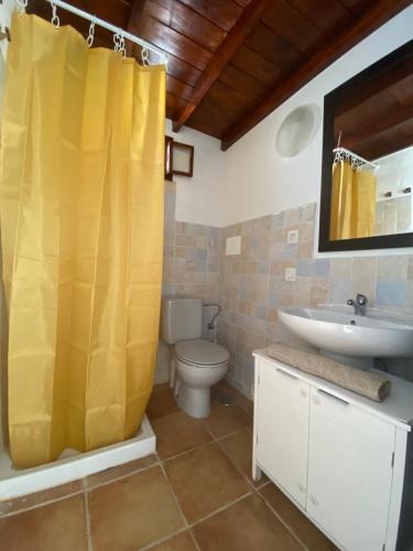 baño con cortina de ducha amarilla y lavamanos en HAPPY HOUSE NANE en Playa Honda