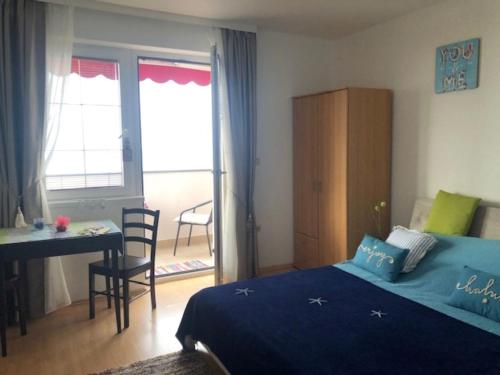 a bedroom with a bed and a table and a desk at Studio Apartment Blue Dream in Ičići