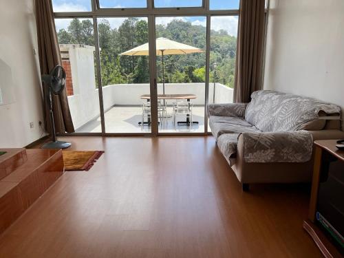 ein Wohnzimmer mit einem Sofa und einem Tisch in der Unterkunft THE MILKY WAY @ PINE RESORT in Bukit Fraser