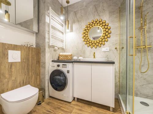 a bathroom with a washing machine and a sink at Glow Apartments, Apartamenty przy Chmielnej Śródmieście in Gdańsk