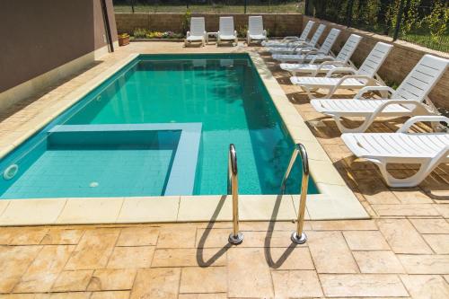 ein Pool mit Chaiselongue daneben in der Unterkunft Hotel Zonya in Sonnenstrand