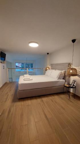 sypialnia z dużym łóżkiem i drewnianą podłogą w obiekcie Costa d'oro w mieście Tolo