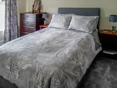 1 cama con edredón blanco y cómoda en Beech Cottage, en Hepple