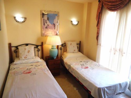 1 dormitorio con 2 camas, lámpara y ventanas en Edison Bungalow Duplex LEK, en Peñíscola