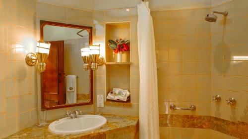 a bathroom with a sink and a mirror at Paraa Safari Lodge in Paraa