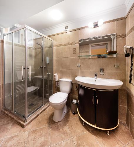 a bathroom with a toilet and a shower and a sink at Hotel Vécsecity in Hernádvécse