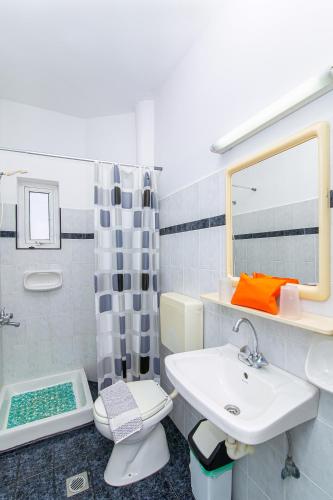a bathroom with a sink and a toilet and a mirror at Sunshine Garden Apts in Malia