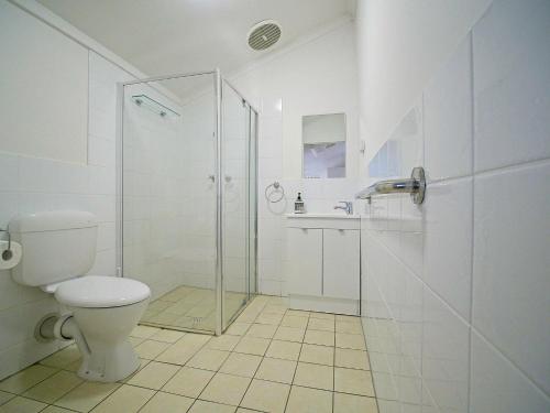 a white bathroom with a shower and a toilet at Sea Salt at Stansbury Apartment 1 in Stansbury
