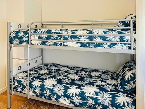 a bedroom with bunk beds with blue and white bedding at Sea Salt at Stansbury Apartment 1 in Stansbury
