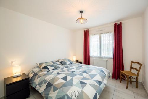 a bedroom with a bed and a table and a chair at Dahouët - Charmante maison pour 6 voyageurs in Pléneuf-Val-André