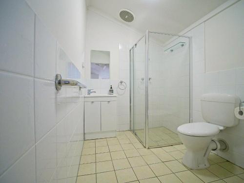 a white bathroom with a shower and a toilet at Sea Salt at Stansbury Apartment 2 in Stansbury
