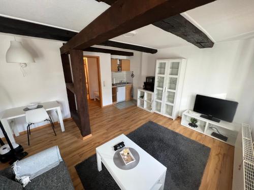 ein Wohnzimmer mit einem weißen Tisch und einem TV in der Unterkunft Ferienwohnung Weser 3 in Holzminden