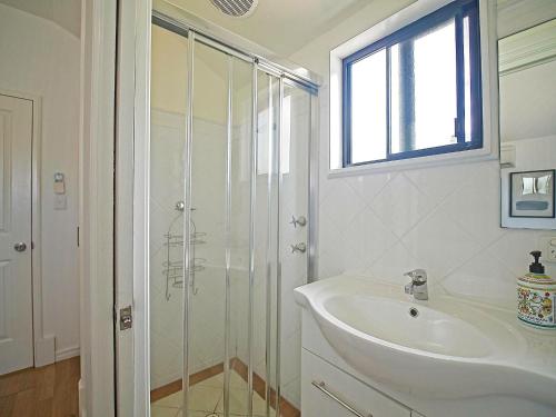 a white bathroom with a sink and a shower at Sea Salt at Stansbury Apartment 3 in Stansbury