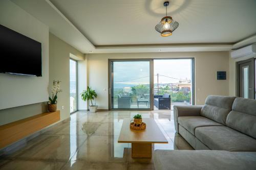 a living room with a couch and a table at Jarko Luxury Houses in Argoulidhés