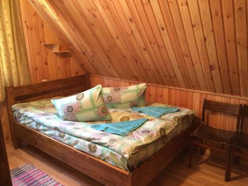 ein Bett in einer Hütte mit einer Holzwand in der Unterkunft У Сергія in Lumshory