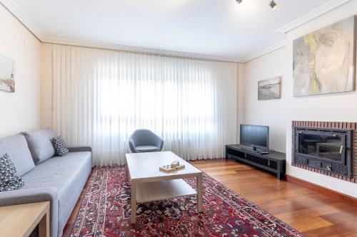 a living room with a couch and a tv at Bilbao Costa II with parking by Aston Rentals in Getxo