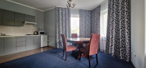 a dining room with a table and chairs and a kitchen at Chernivtsi Apartments in Chernivtsi