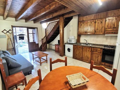 a kitchen and living room with a table and chairs at Tríplex con patio y BBQ en La Vall de Boí in Cardet
