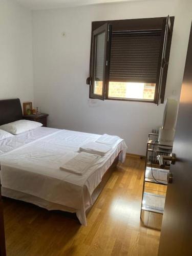a bedroom with a white bed and a window at Apartment in Becici in Bečići