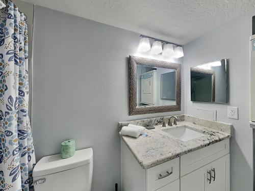 a bathroom with a sink and a toilet and a mirror at Madeira Beach Yacht Club 261f in St Pete Beach