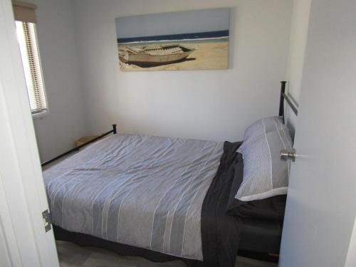 a bedroom with a bed and a picture of a boat at The Shack at Hardwicke in Hardwicke Bay