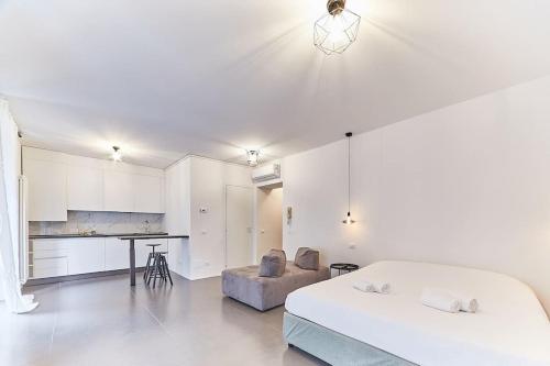 a white bedroom with a bed and a kitchen at The Suite in Milan