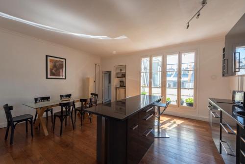 une cuisine avec une table et des chaises dans une pièce dans l'établissement Colonnade, à Paris