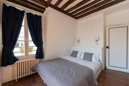 une chambre avec un lit et une fenêtre dans l'établissement Colonnade, à Paris