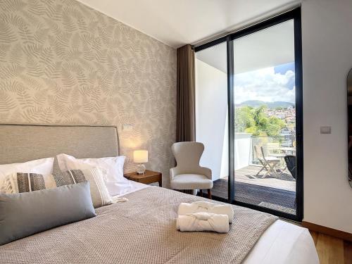 een slaapkamer met een bed en uitzicht op een balkon bij Funchal Frui Vita by Atlantic Holiday in Funchal
