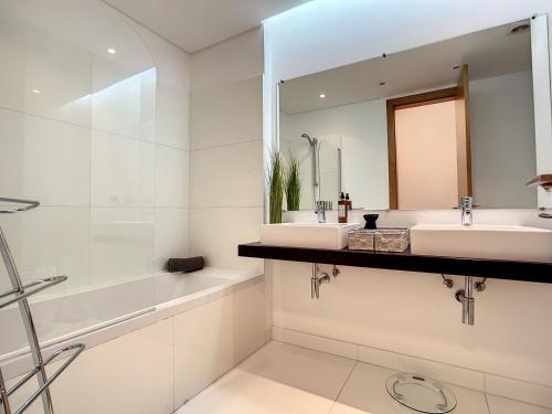 a bathroom with two sinks and a mirror at Funchal Frui Vita by Atlantic Holiday in Funchal