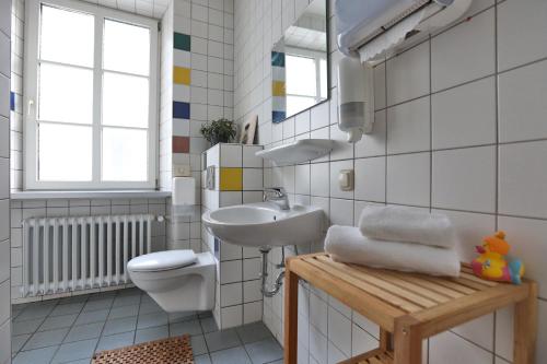 bagno bianco con lavandino e servizi igienici di Kolping Hostel Trier im Warsberger Hof a Treviri