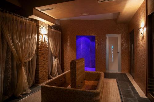 a room with a large tub with a blue door at Hotel Fiordigigli in Assergi